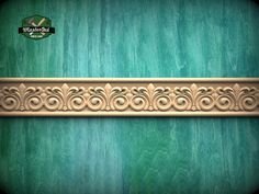 an ornate wooden frame on a green wall