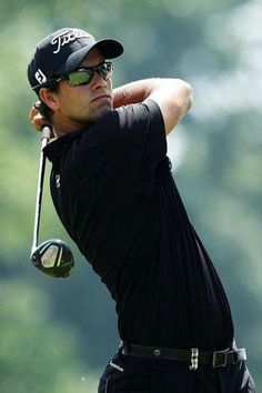 a man in black shirt and sunglasses playing golf