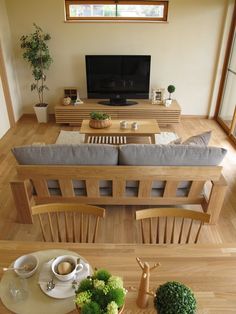 a living room filled with furniture and a flat screen tv on top of a wooden table