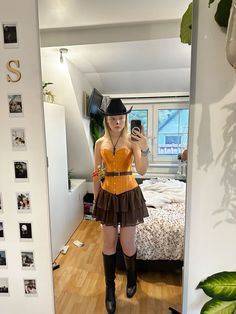 a woman is taking a selfie in the mirror while wearing boots and a cowboy hat