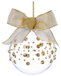 a glass ball ornament with gold and white decorations on the top, hanging from a string