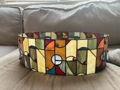 a stained glass bowl sitting on top of a couch