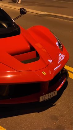 a red sports car is parked on the street