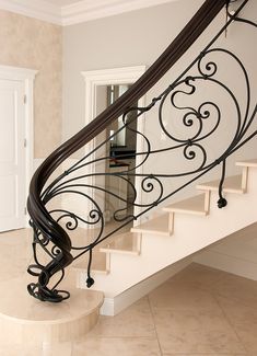 a staircase with wrought iron handrails in a home's entryway area