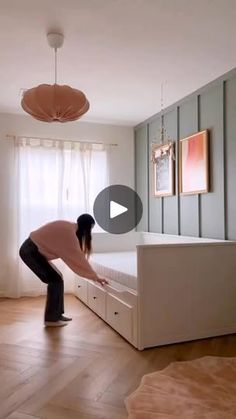 a woman is bending over to look at the bed