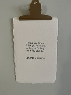 a piece of paper with a quote on it hanging from a clipboard attached to a wall