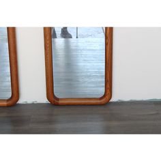 two mirrors sitting on top of a wooden floor