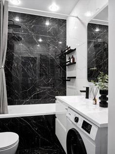 a black and white bathroom with marble walls