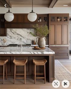 a kitchen with marble counter tops and stools next to an island in the middle