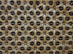 a close up view of a bamboo wall with geometric designs on the outside and inside