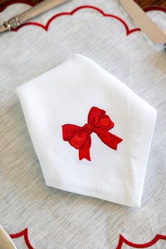 an embroidered red bow on a white napkin