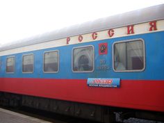 a blue and red passenger train sitting on the tracks