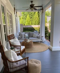 a porch with wicker furniture on it and a ceiling fan hanging from the ceiling