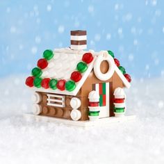 a gingerbread house made out of legos on top of snow with the words gingerbread house below it