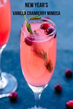 two glasses filled with liquid and garnished with cranberries