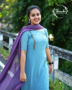 a woman wearing a blue dress and purple shawl