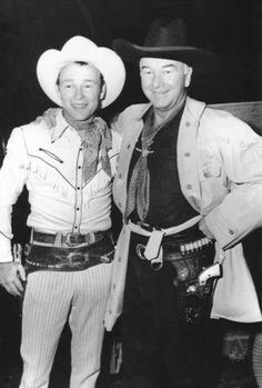 two men dressed in cowboy attire posing for a photo