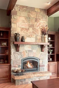 a living room filled with furniture and a fire place in the middle of a fireplace