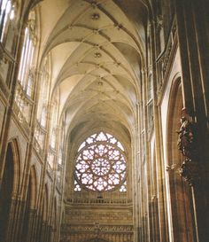 the interior of a cathedral with large stained glass windows