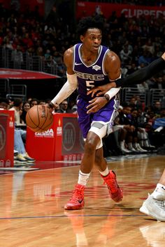 a basketball player dribbles the ball while being guarded by another player