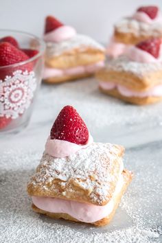 strawberry shortcakes with powdered sugar and fresh strawberries in a glass bowl