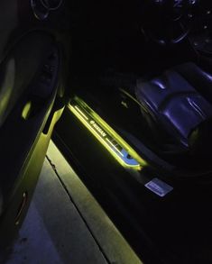 the interior of a car with its lights on at night, and it's door open