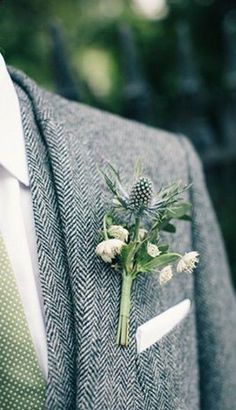 a man wearing a suit and tie with a boutonniere on his lapel