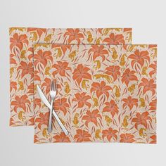 two place mats with silverware on them, one is orange and the other is yellow