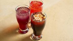 three glasses filled with different types of drinks