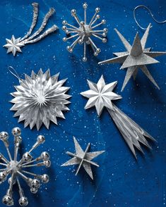 silver christmas ornaments on a blue background with snowflakes and stars in the middle