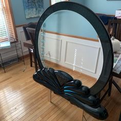 a mirror sitting on top of a wooden floor in front of a table with chairs