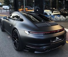 a black sports car parked in front of a building