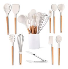 the kitchen utensils are lined up in a white cup with wooden spoons