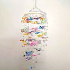 a wind chime hanging from the ceiling with many colorful butterflies and beads on it