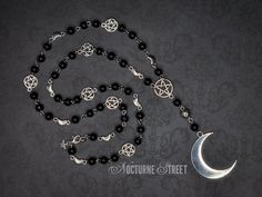 A beautiful gothic rosary, handmade by Nocturne Street. Featuring a large silver moon suspended from a pentagram. The chain is made from black glass beads, dotted with silver moons and pentagrams. The charms used in this pieces are made from Tibetan Silver and the necklace fastens with a silver plated lobster clasp, although it can fit over the head. The rosary chain measures about 28 inches when unclasped and laid flat. The moon measures 35x45mm. This moon rosary will be packaged in a pretty organza gift bag and would make a lovely gift. It would look perfect with a trad goth or whimsigoth outfit. Visit my shop to see the complete collection of gothic earrings. Only pay one lot of postage, the rest of your order ships free! ✨ Gothic Handmade Jewelry, Silver Jewelry With 108 Beads For Festivals, Gothic Silver Jewelry With Round Beads, Silver Gothic Jewelry With Round Beads, Silver Jewelry With Round Beads For Halloween, Halloween Silver Jewelry With Round Beads, Bohemian Silver Rosary For Jewelry Making, Gothic Silver Necklaces With Round Beads, Gothic Silver Necklace With Round Beads