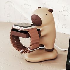 a cell phone is plugged in to a bear - shaped device holder that holds an ipod