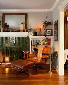 a living room with a chair, fireplace and potted plants on the mantles