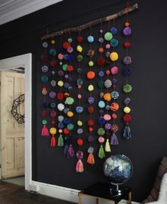 a room with black walls and lots of pom poms hanging on the wall