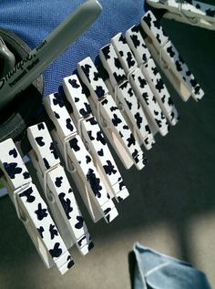 several pairs of scissors are hanging on clothes pegs with black and white crosses painted on them