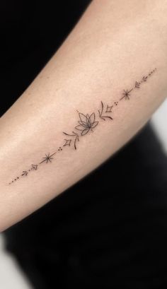 a woman's arm with a flower tattoo on the left side of her arm