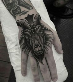 a hand with a goat head on it and a pentagramil in the middle