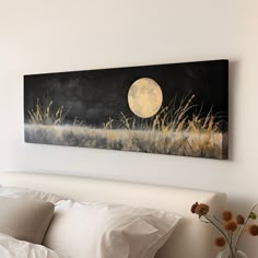 a painting hanging on the wall above a bed in a room with white sheets and pillows