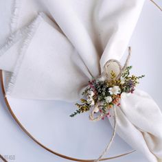 the napkin is tied with twine and has flowers on it, along with a ring