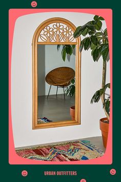 a mirror that is on the wall next to a potted plant