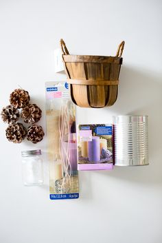 pine cones, tins and other items are arranged on a white surface next to a basket