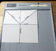 a piece of paper that has been cut into squares and is sitting on top of a cutting board