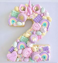 the number two made out of cookies is decorated with rainbows and other sweets on it