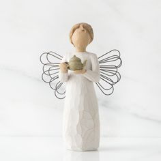 a ceramic angel figurine holding a potted plant