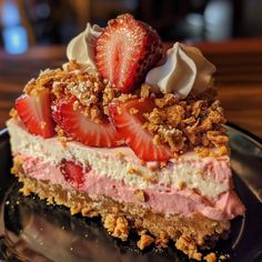 a piece of cake with strawberries and whipped cream on top sits on a plate