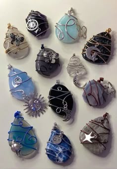 twelve glass pendants are arranged on a white surface, one is blue and the other is black